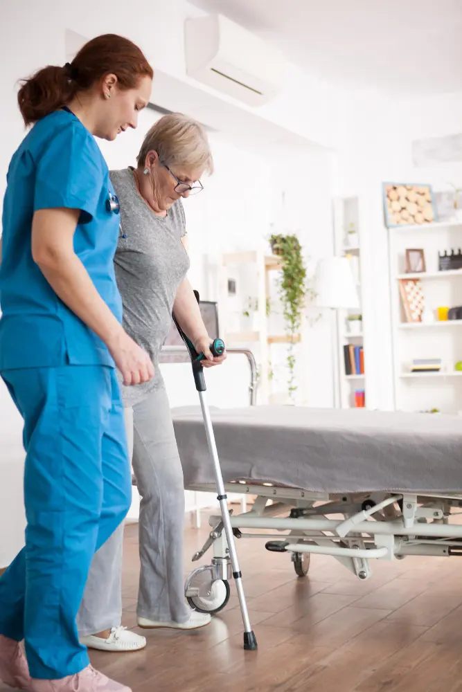 A physical therapist assisting a women with crutches during early recovery after hip replacement surgery.