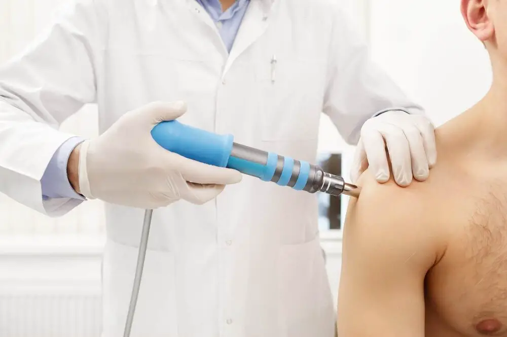 Extracorporeal shock wave therapy being applied to the shoulder for treatment of a calcific tendon deposit.